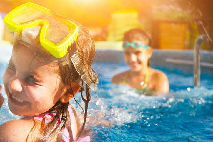 Children playing in pool. Two little girls having fun in the pool. Summer holidays and vacation concept