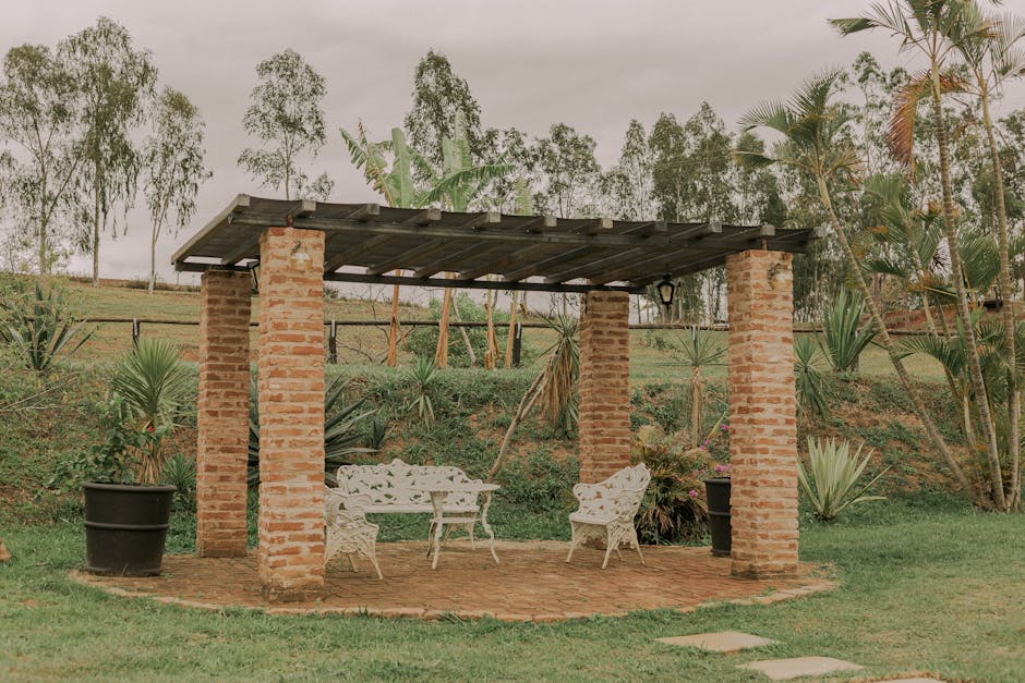 Powder-coated aluminum patio furniture arranged under a Florida pergola with lush landscaping