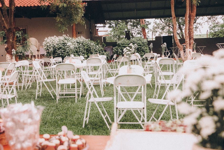 Rows of white powder-coated aluminum stack chairs arranged for an outdoor Florida wedding ceremony