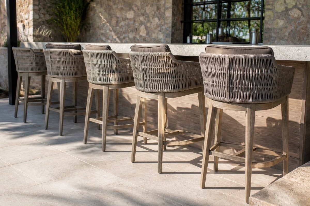 outdoor swivel bar stools with circular footrests on a covered Florida patio