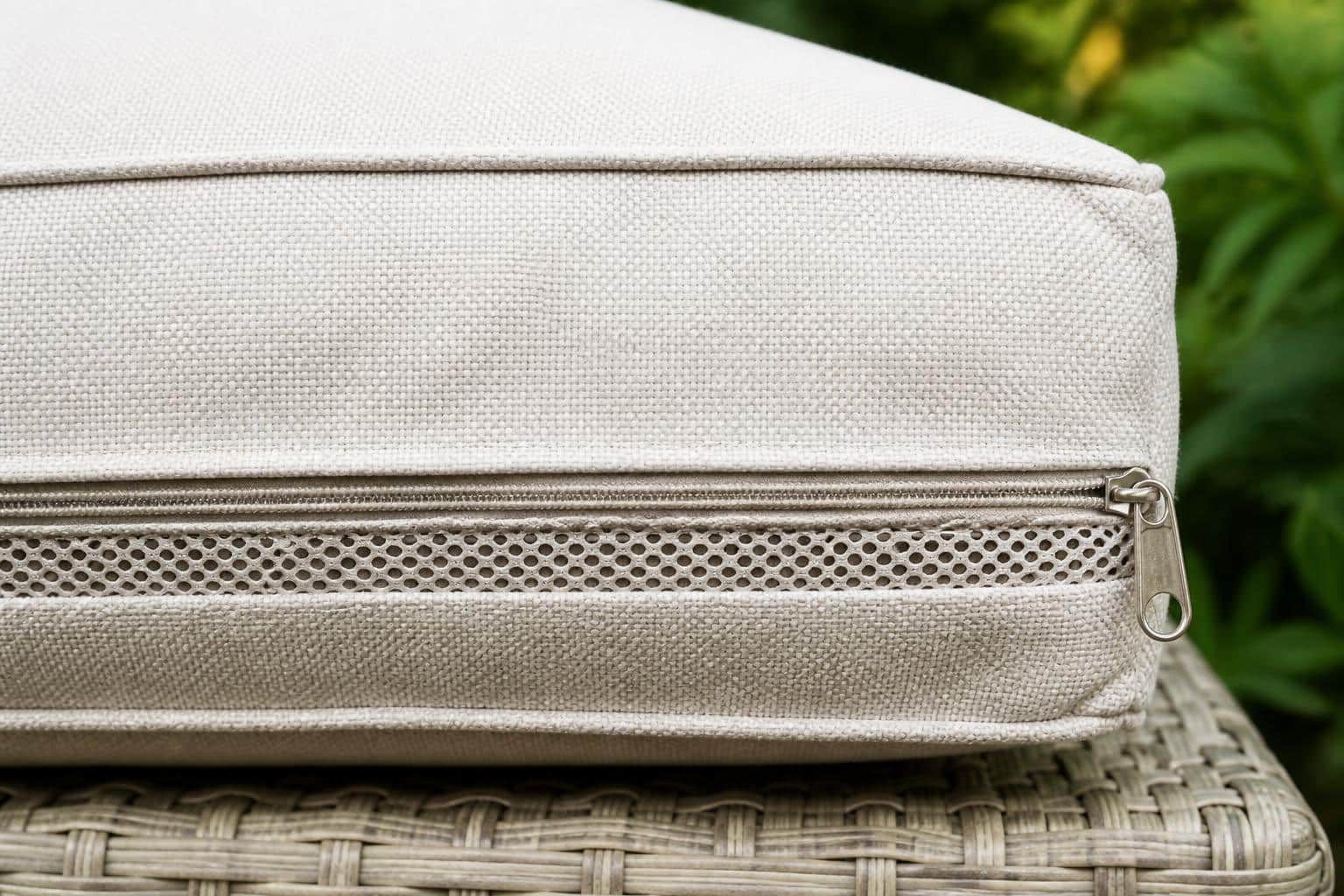 Close-up of a plastic coil zipper along the back edge of an outdoor patio cushion