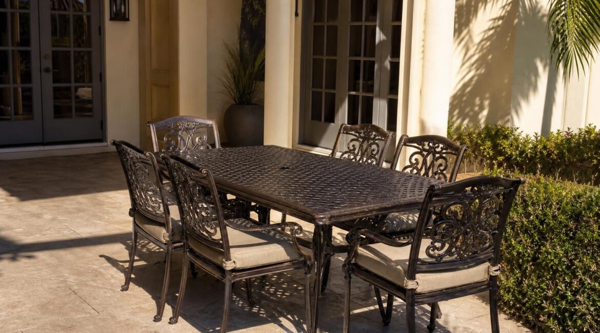 A matched set of powder-coated bronze aluminum patio chairs and a dining table on a Florida patio in bright afternoon light