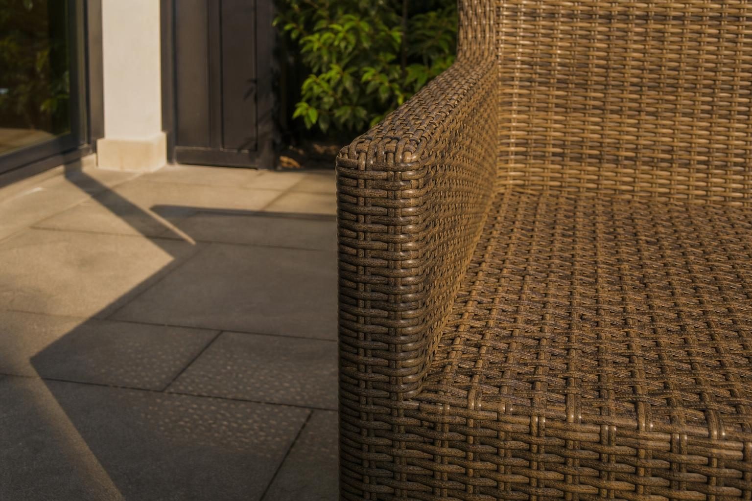 Close detail of tightly woven all-weather wicker patio chair texture in sunlight
