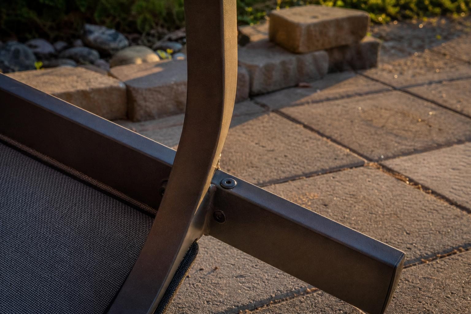 Close view of where two aluminum frame tubes join under a patio chair