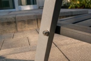Bolt and nut joining an aluminum patio chair leg to the seat frame